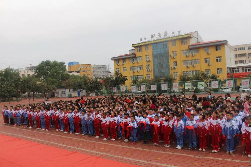 迎着金秋的阳光,一面鲜红的中国少年先锋队队旗在小旗手刘梓森,韩泽君