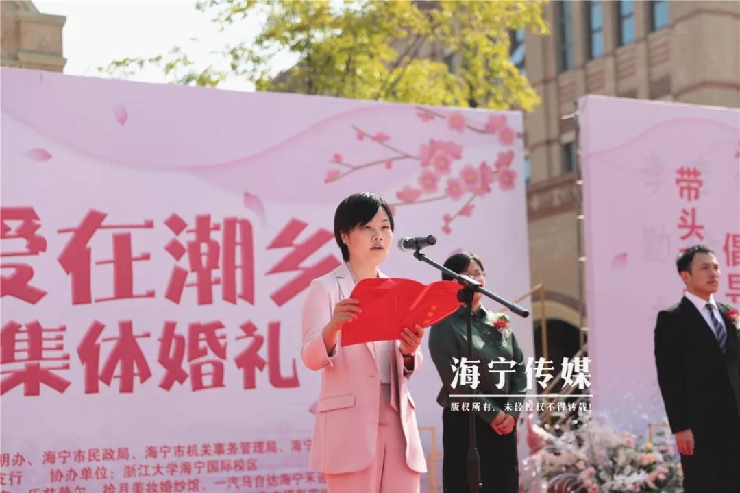 在巍峨的钟楼下,海宁市人民政府副市长沈勤丽为新人们证婚,致证婚词.