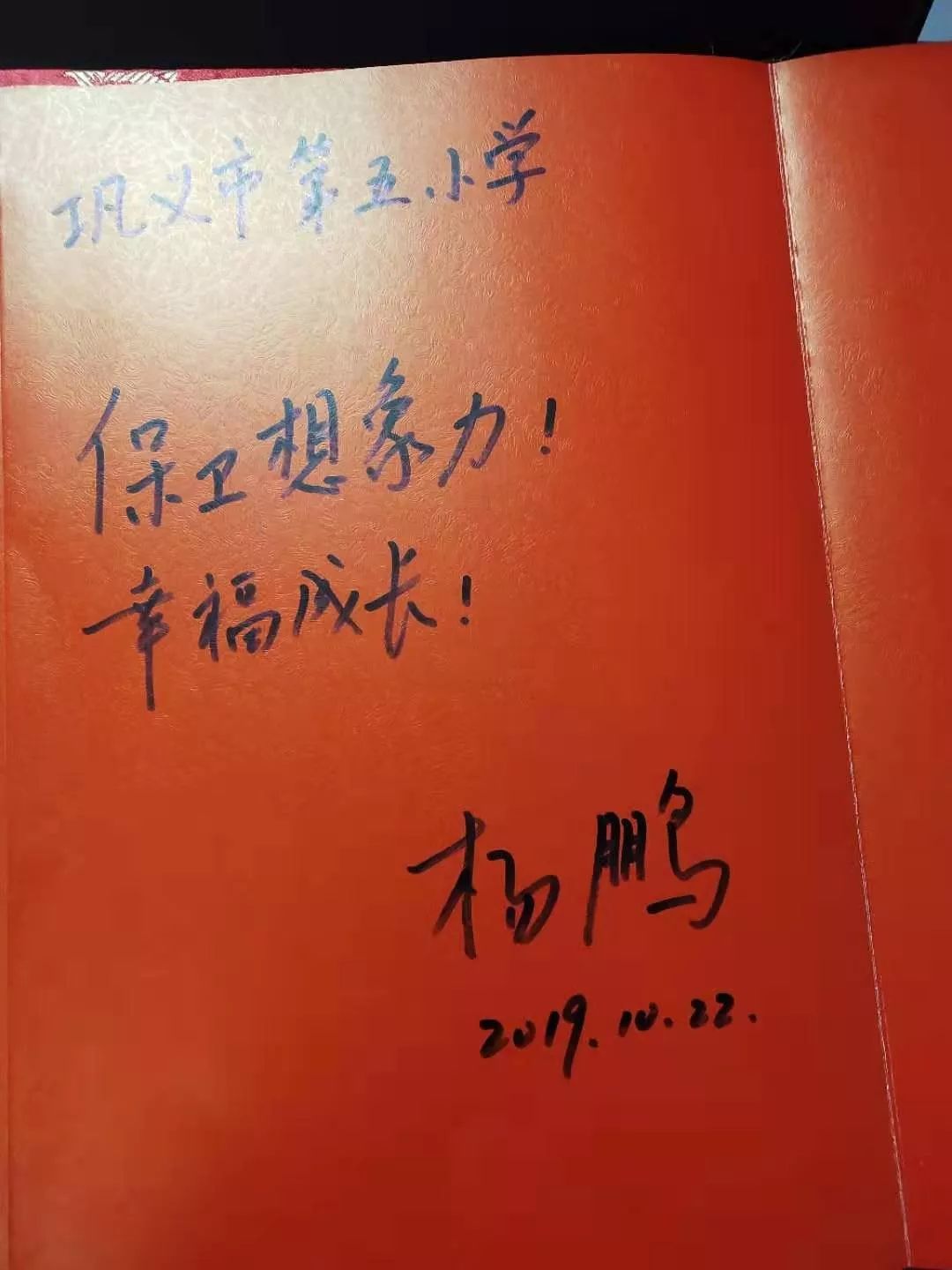 杨鹏老师为师生们签字.校领导班子和杨鹏老师作家团队合影.