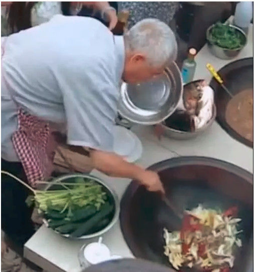 赵本山灶台前炖鱼，动作娴熟有大厨风范，身边围着一圈帮厨排场大