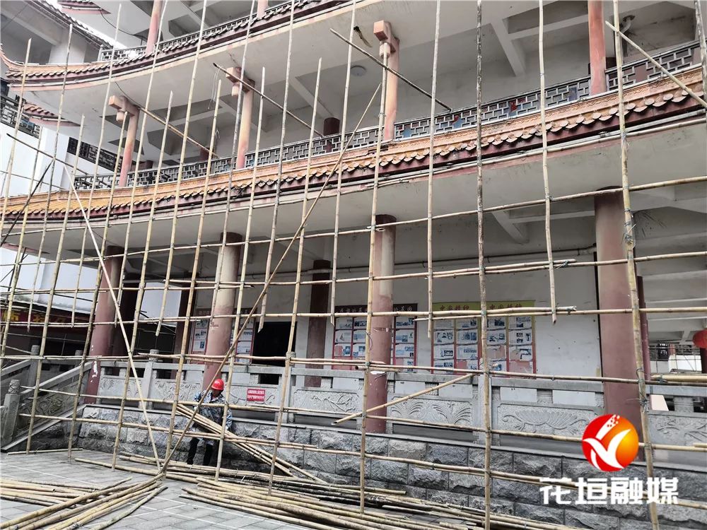 边城图书馆主楼外墙搭建竹架,工人们将进行粉刷修缮