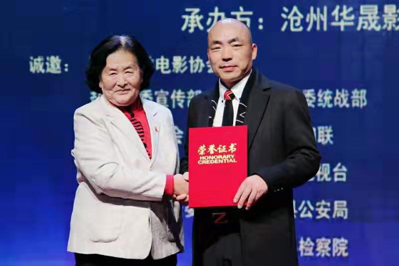 盐山县关工委副主任陈家英为沧州华晟影视导演李国良颁发优秀导演证书沧