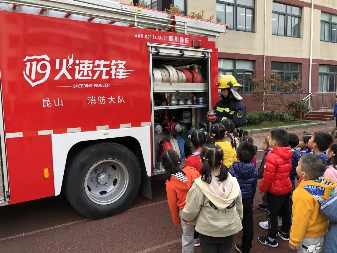 "一辆消防车停在幼儿园门口,各班孩子有序的参观消防车装备.