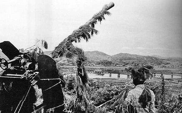志愿军进入朝鲜后,高射炮兵某部伪装兵器,高度警惕守卫着大宁江桥