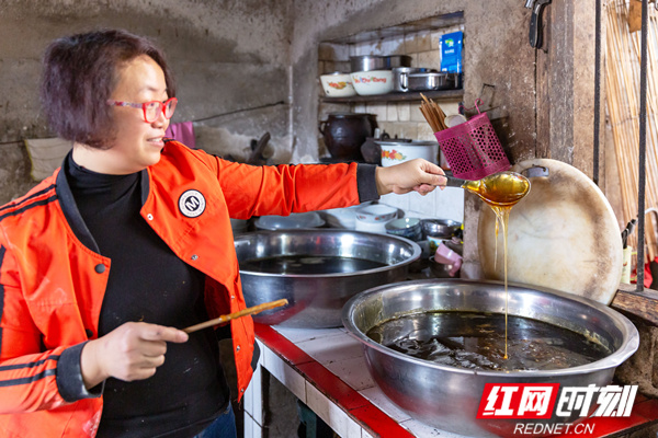 中田橙子糖第五代制作艺人胡学祥女儿展示麦芽糖,扯拉成丝,绵绵不绝.