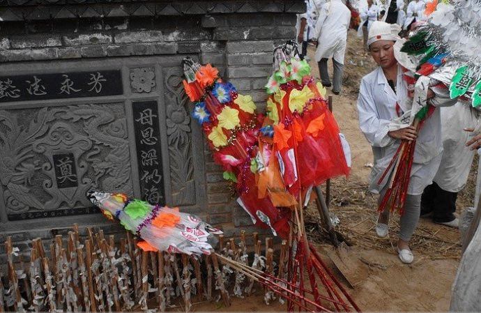 将孝子棒密密麻麻地插在坟前,再献上花圈.