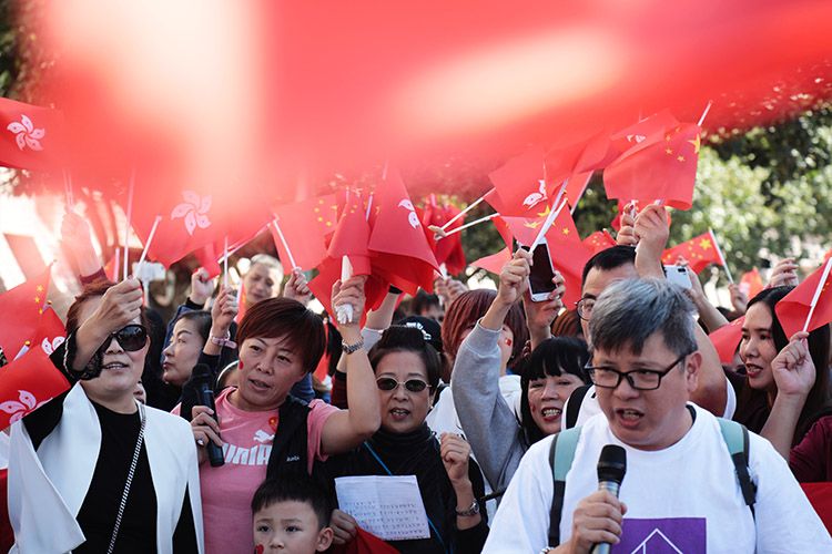 爱国,爱港人士挥舞中华人民共和国国旗和香港特别行政区区旗,合唱爱国