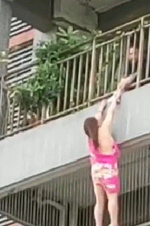 惊险！东莞居民楼阳台外悬挂一女子，摇摇欲坠！