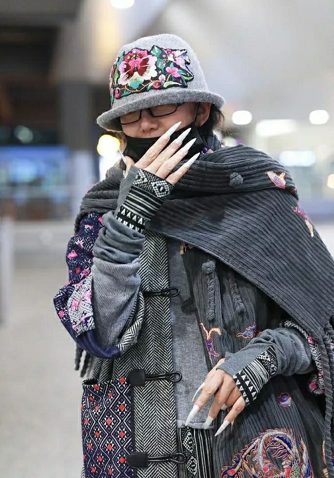 61岁杨丽萍现身机场，白色长指甲非常吸睛，民族风装扮有个性_孔雀舞