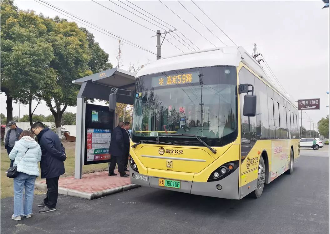 在太仓陆渡崇恩寺公交站,乘客登上一辆挂着沪a牌照的嘉定59路公交车.