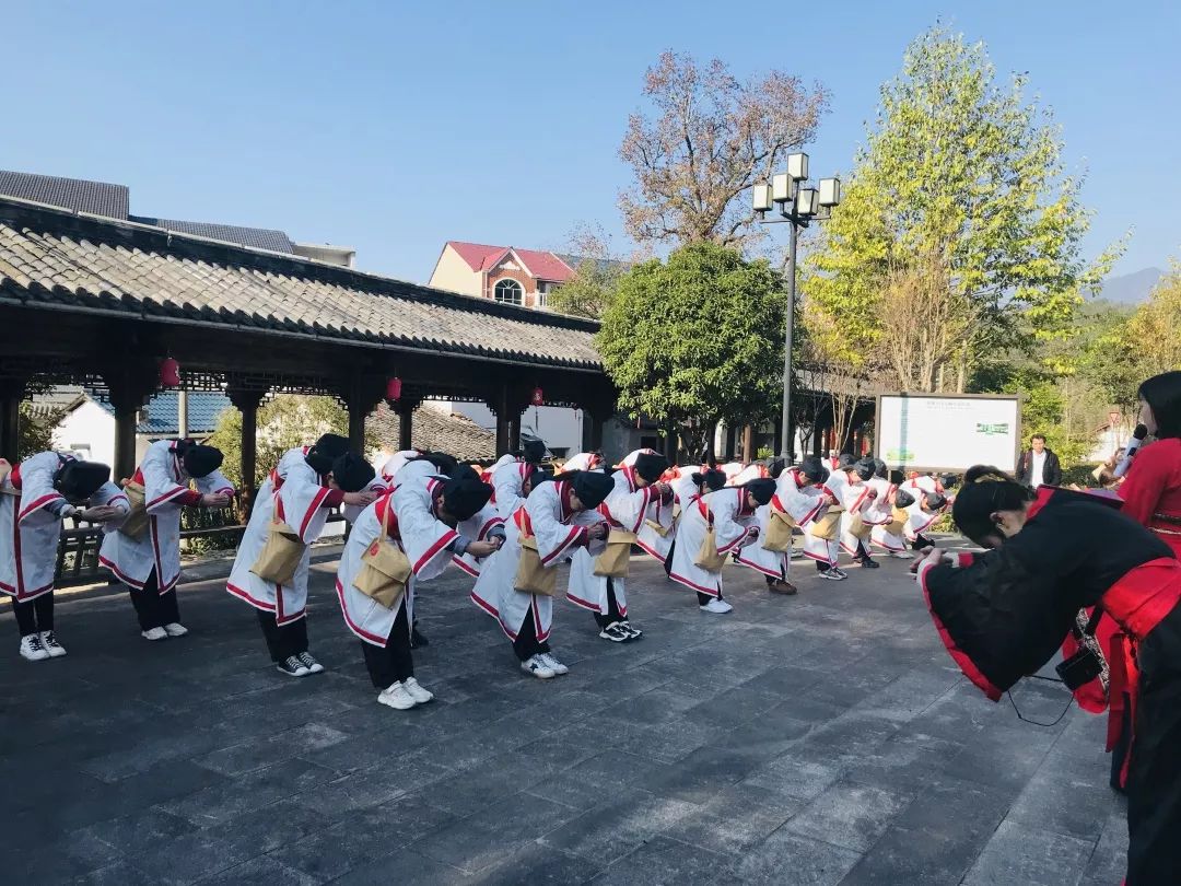 在本次的活动中主持人带领学生们在八都镇章府会内的章溢广场讲解关于