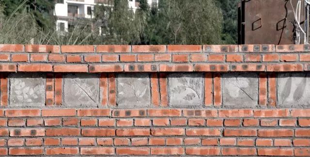 小朋友参与制作的水泥砖砌在了乐园的矮墙上.