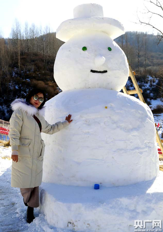 游客与雪人合影(央广网记者 张雷 摄)