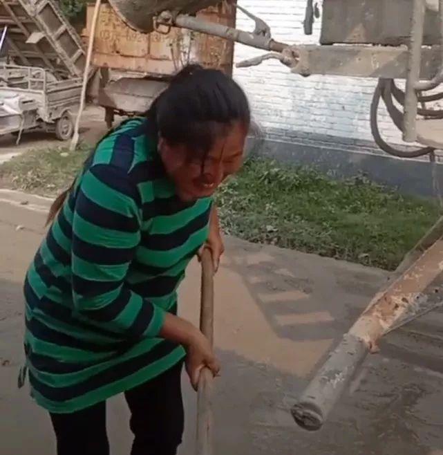 大衣嫂架子底下锄水泥,泥水路上弯腰干活卖力,网友:不