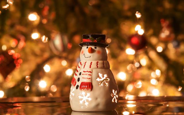 a lighted candle outside houses during the christmas season