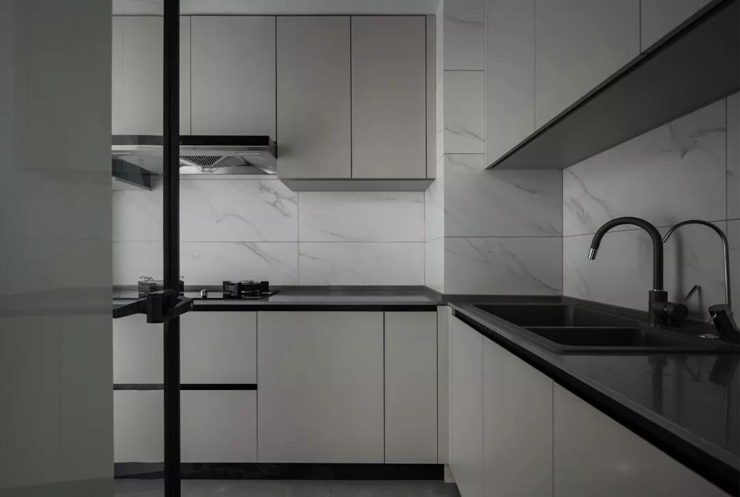 厨房,整体定制浅色系橱柜搭配黑色台面,黑框玻璃门隔离油烟,不影响