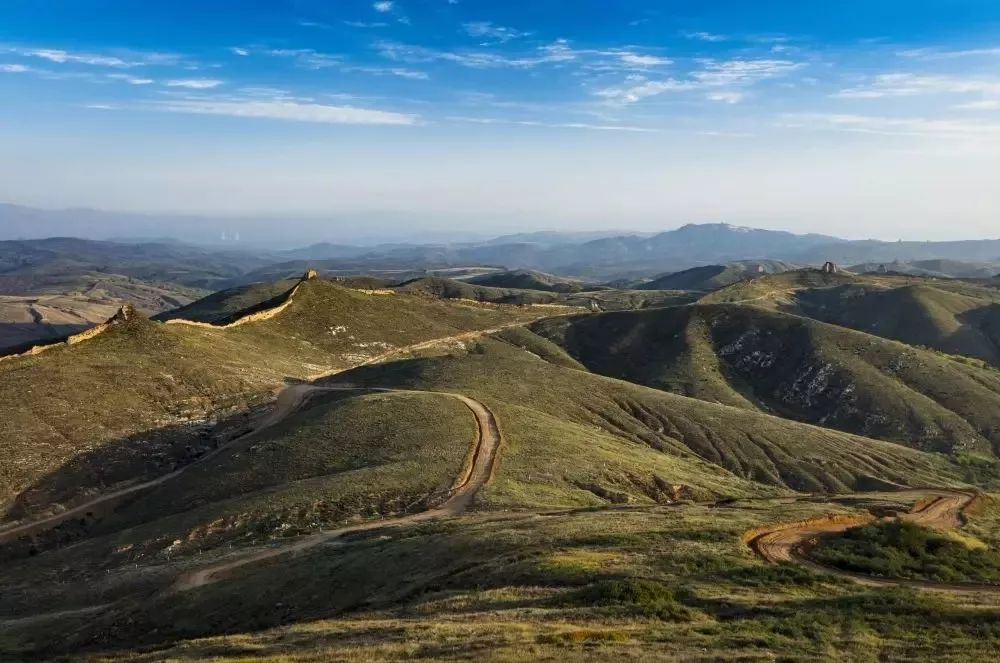 夯土长城因山就势而筑,如黄色巨龙沿桦林山奔腾而来,曲折蜿蜒,盘桓