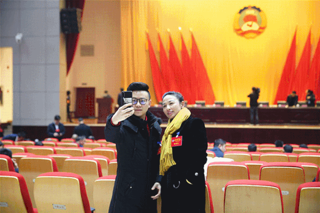 昂首阔步地进入会场 委员们用 手机扫码进行会议签到 并仔细确认墙上