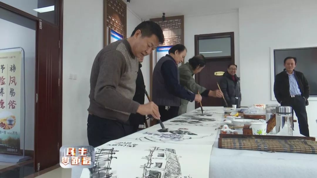 在滕州市历史文化展示馆二楼,十多名老中青年画家挥毫泼墨,认真交流