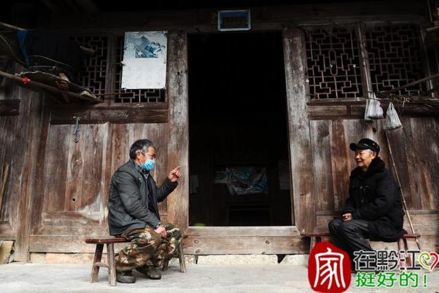 2月4日,重庆市黔江区濯水镇堰塘村1组组长邬光发(左)在给村民宣传防控