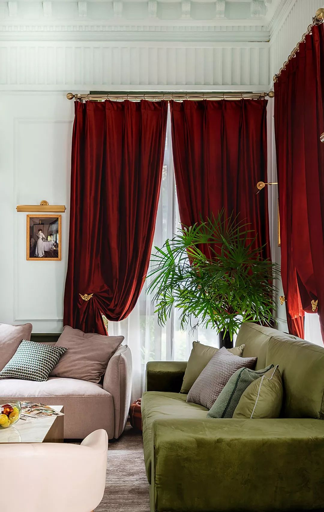 大面积的红丝绒窗帘是主色调,绿色沙发作为辅助色,窗帘上的小天使金色