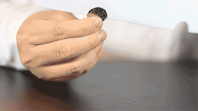 step4将硬币以同样的方式放在另一个洞口上用手轻轻将a4纸往中间挤一