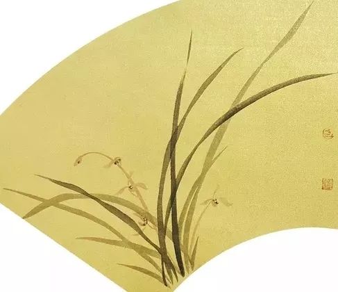 扇面在泥金色的笺纸上题写了四句咏兰诗,又在旁边画了一丛摇曳的兰花
