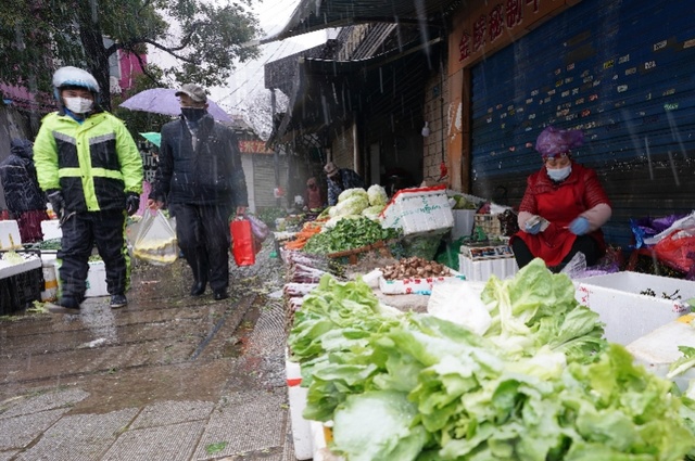 2月15日,雨雪降温天,武汉小东门露天菜市场一角. 新华社发