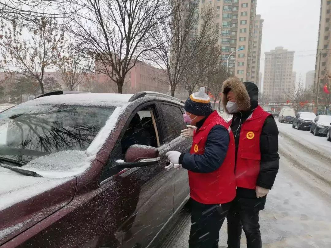 在东丽区,顶秀欣园社区报到的团员青年在风雪中坚守门岗.