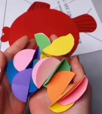 用各种颜色卡纸剪好多小圆形作为鱼鳞,然后把圆形从中间对折.