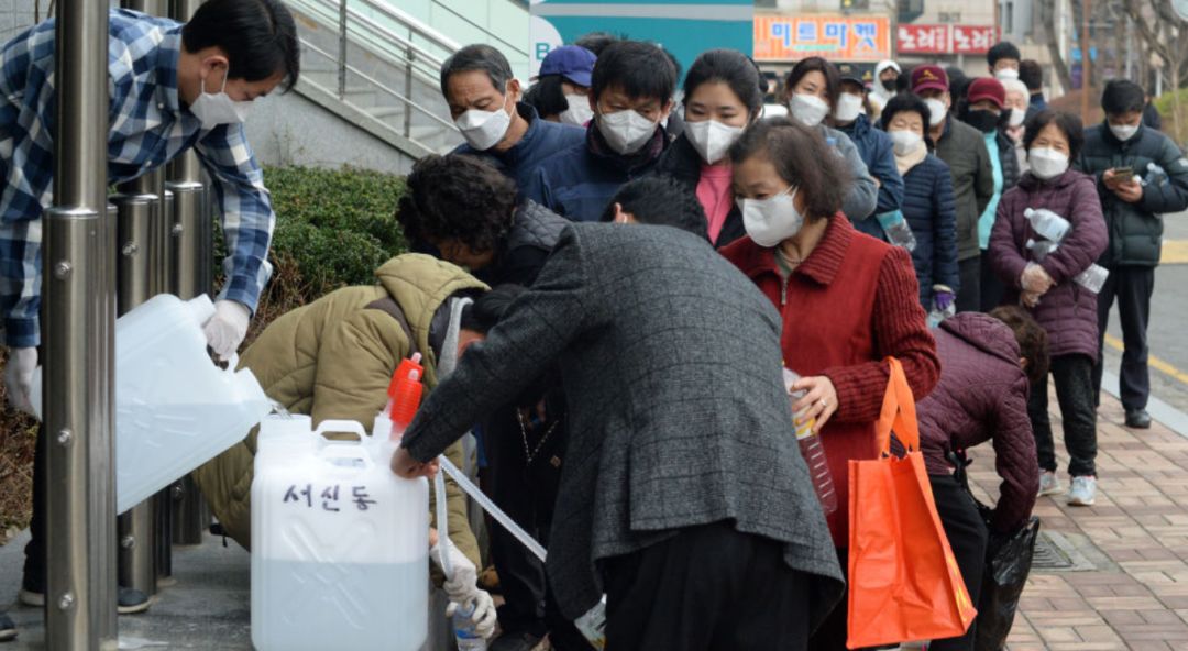 2月26日,在韩国全州,市民排队接取政府提供的消毒液.