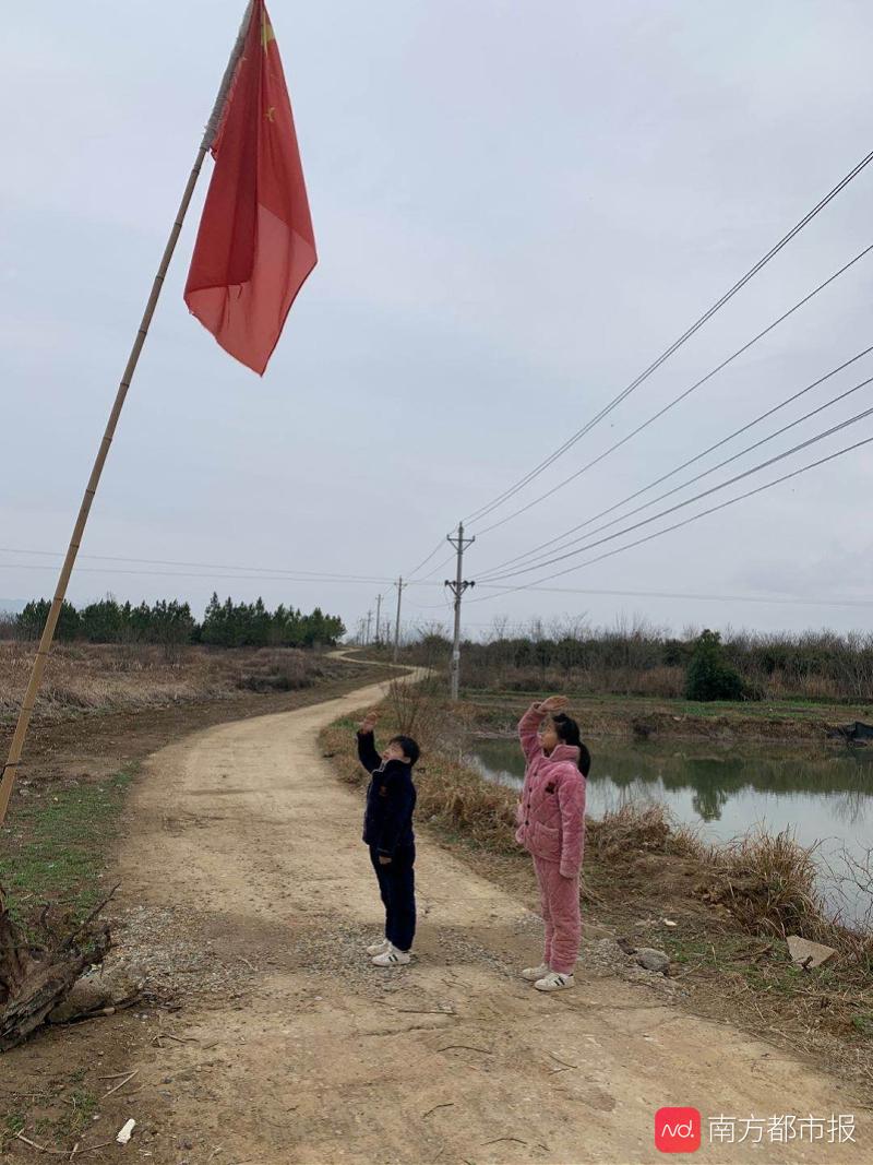 特殊的升旗仪式：滞留湖北的小姐弟在村口向国旗敬礼