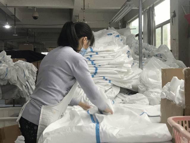 缝制,包装真空包装缝制裁剪工人们正在进行防护服的代加工生产车间内