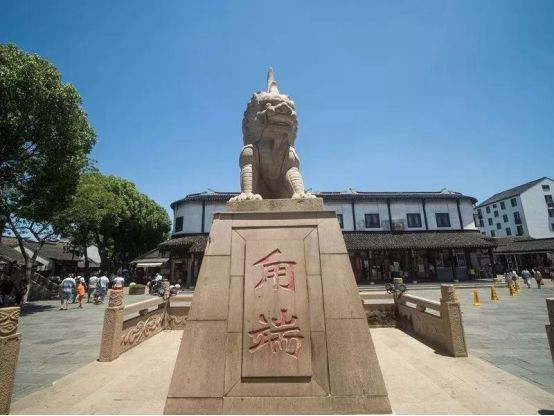 "底座上镌刻着这么一段文字:矗立着一座金山石雕甪端像甪直镇镇区广场