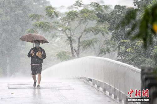 图为一名男子在雨中出行.中新社记者 陈骥旻 摄