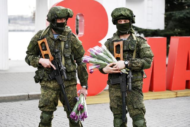 这两名俄军士兵穿着"小绿人"迷彩服,头戴凯夫拉防弹盔,面罩遮住了自己