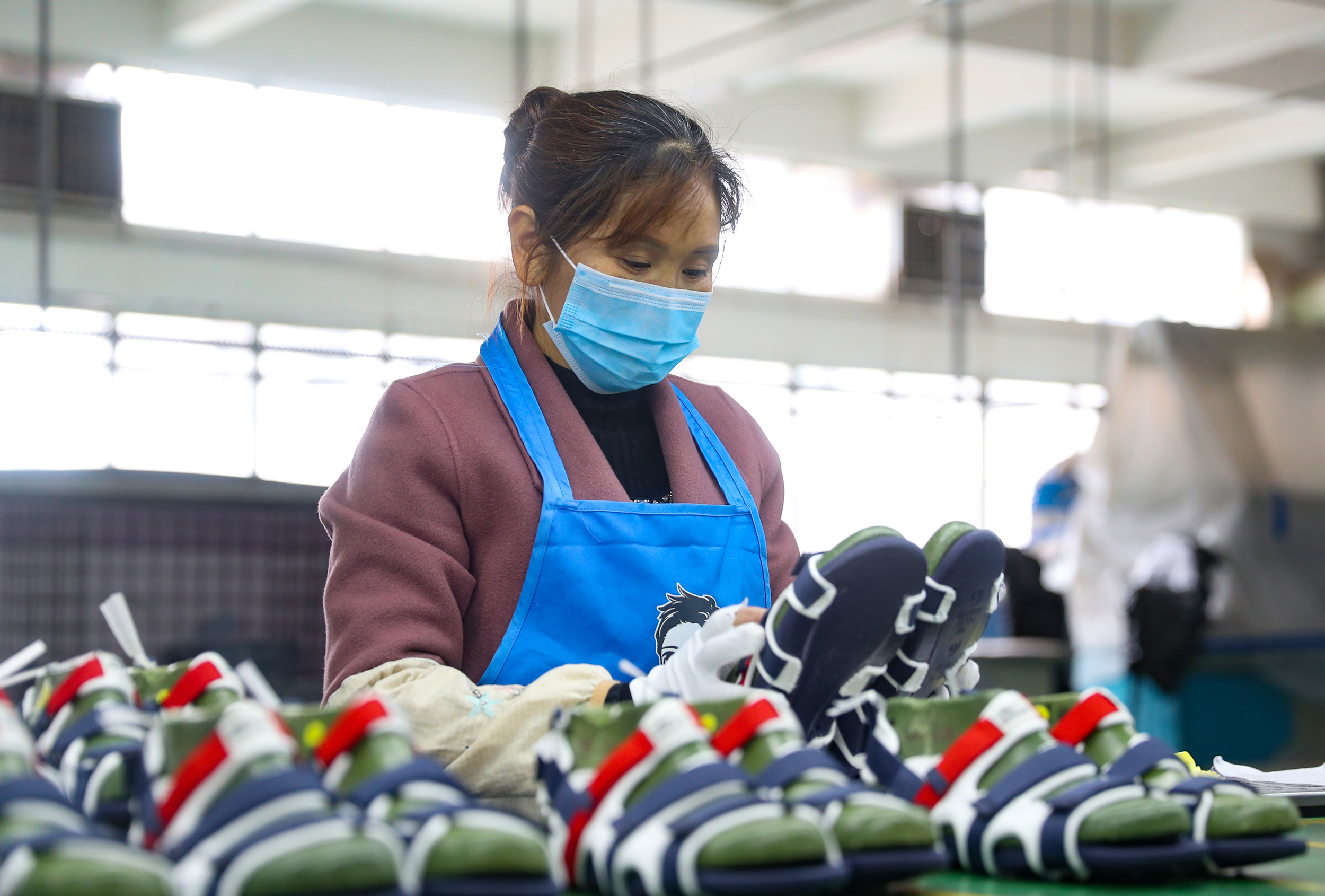 3月9日,四川省广安市前锋区一家外贸制鞋企业的员工在检查鞋的质量.