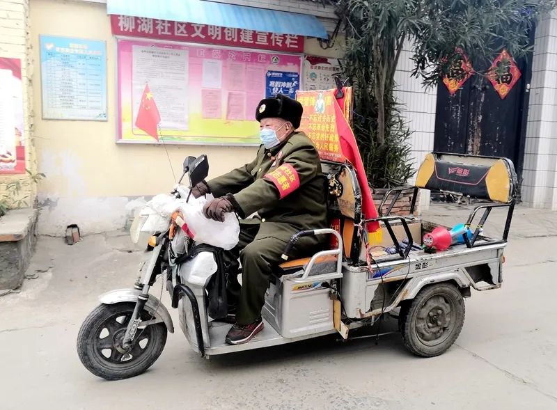 卡点不忙时,张西军就会骑着三轮车到小街小巷做防疫宣传.