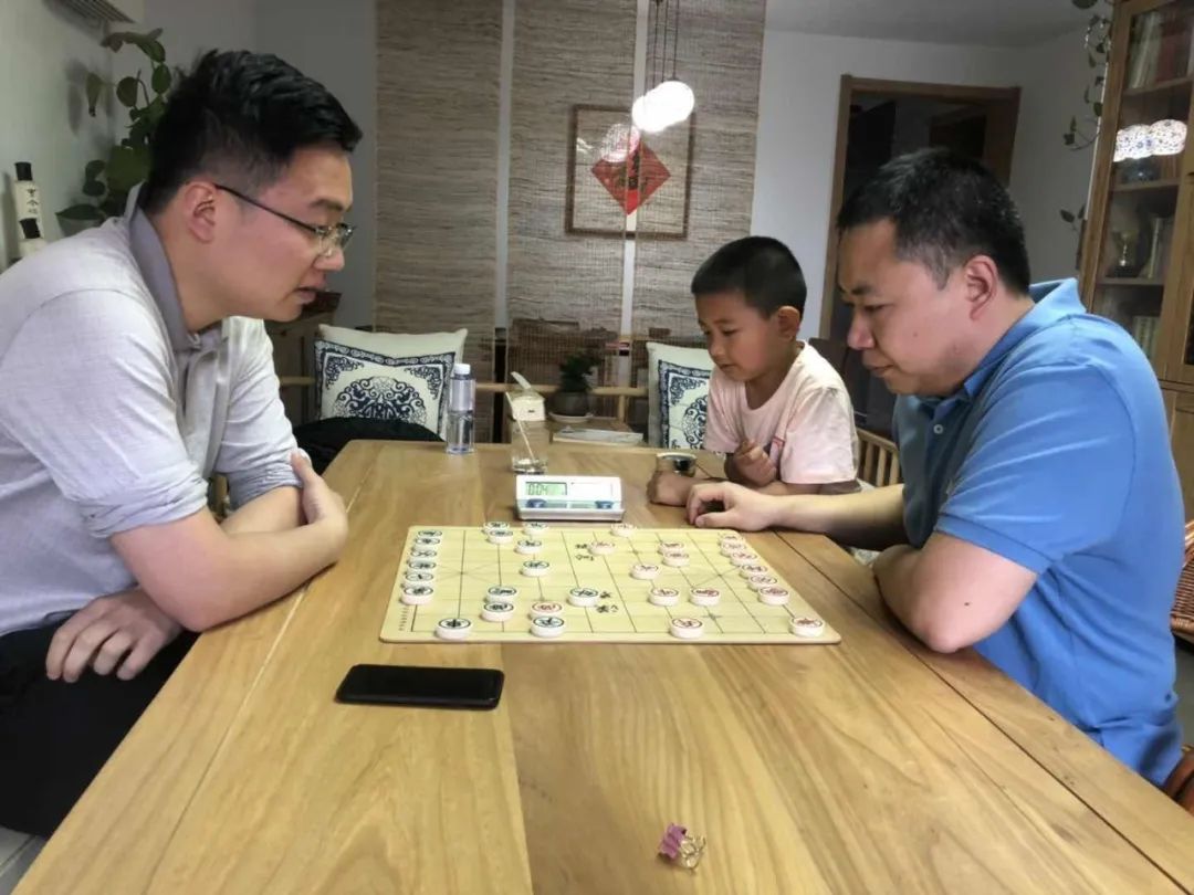 吴思岐观战爸爸吴优与象棋特级大师郑惟桐对弈