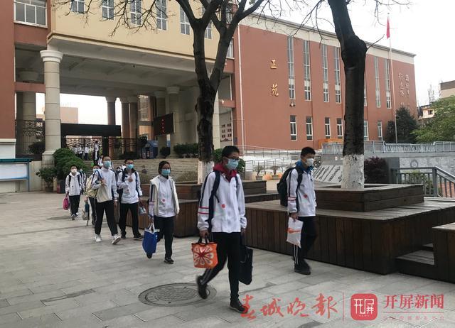 7点10分,昆十中白塔校区学生开始入校.学生排队等待监测体温,方得