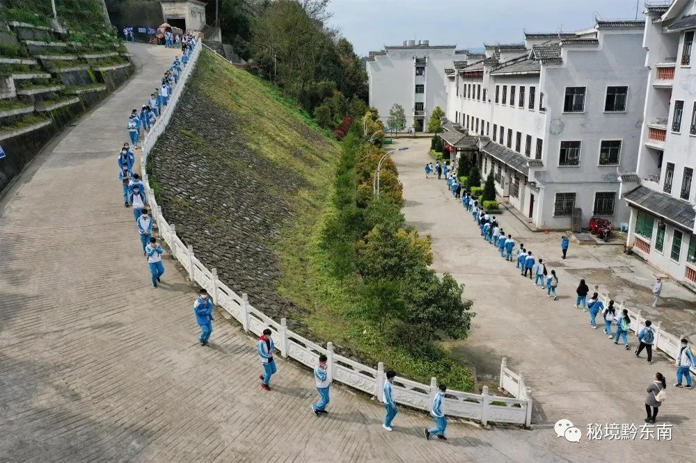 黄平县旧州中学师生保持安全距离进入食堂就餐.