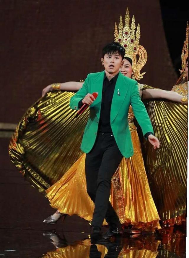 张杰穿绿西装高举红色话筒十分亮眼,应景演唱歌曲《百万富翁》