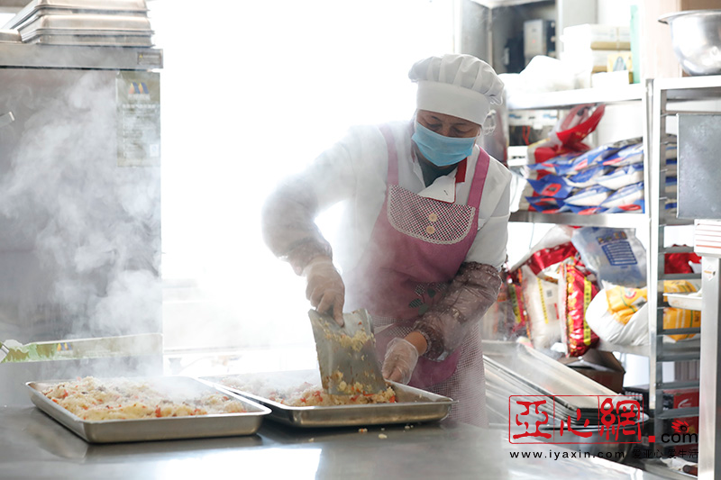 3月26日,在乌鲁木齐市第四中学食堂操作间内,防护措施齐全的工作人员