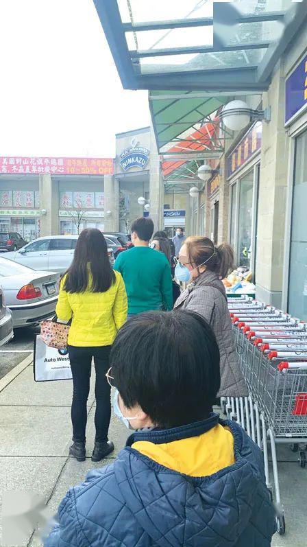 市民昨日戴口罩,分隔排队进入超市.