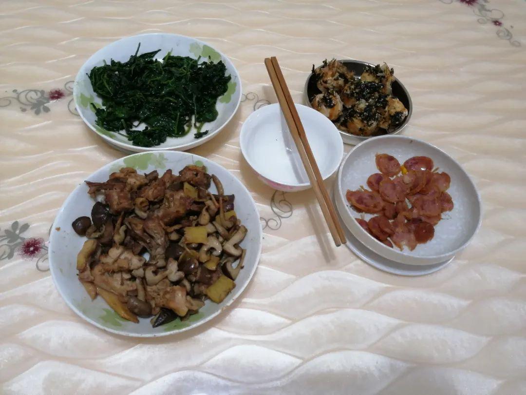 向记者展示自家的餐桌:两荤两素,中间还特地放了一个干净的碗装公筷