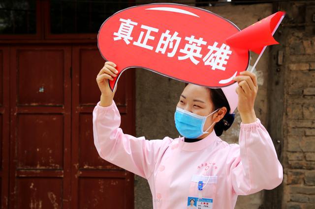 抗疫英雄凯旋归来 白衣天使们自发持小国旗夹道欢迎