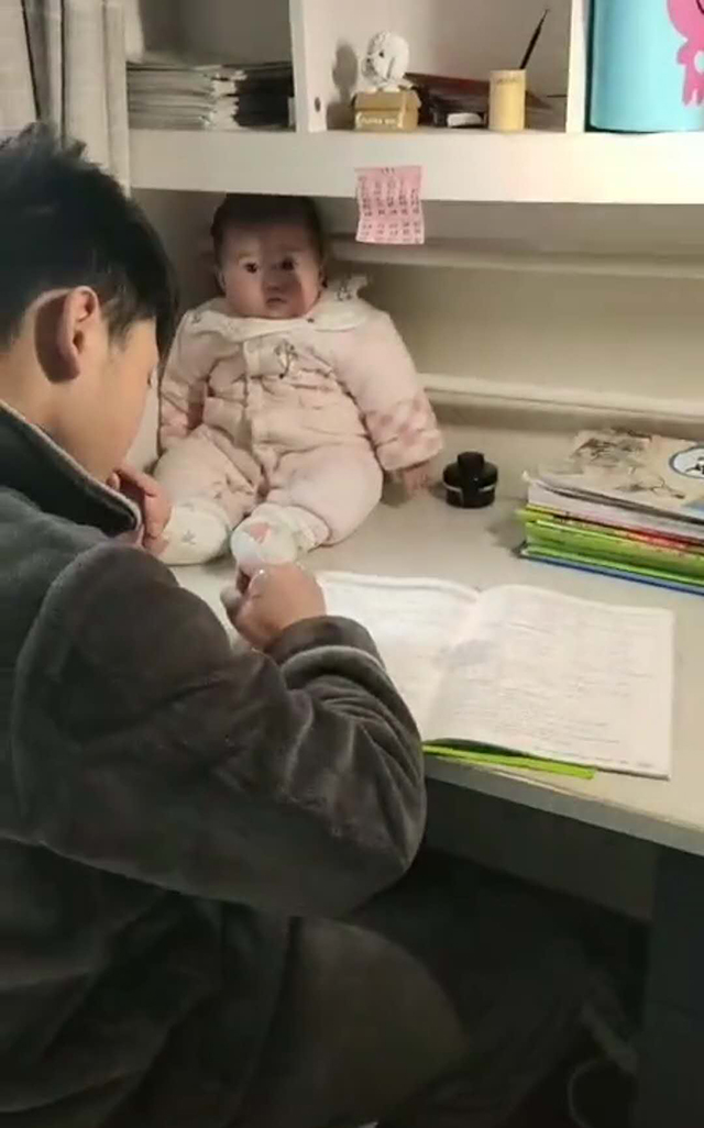哥哥做试卷遇到难题，把妹妹拎来当“吉祥物”，妹妹乖巧模样萌翻众人