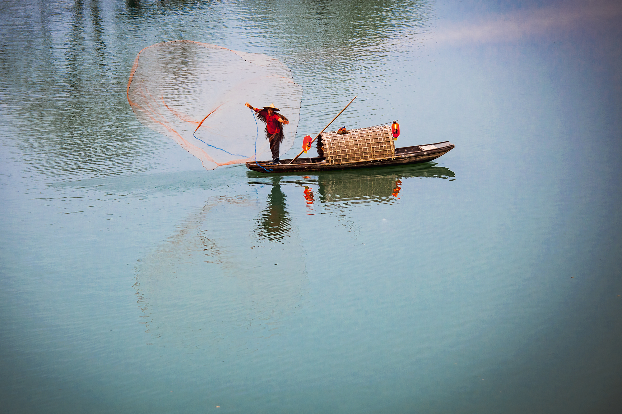 一湾湖水如弯月静卧水面,渔夫在打鱼,美的画卷