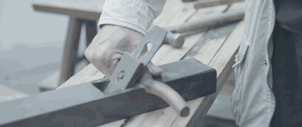 左手拿着刨子,右手用锤子敲击刨刀入,敲击尾部木头退,以此调整刨刀的