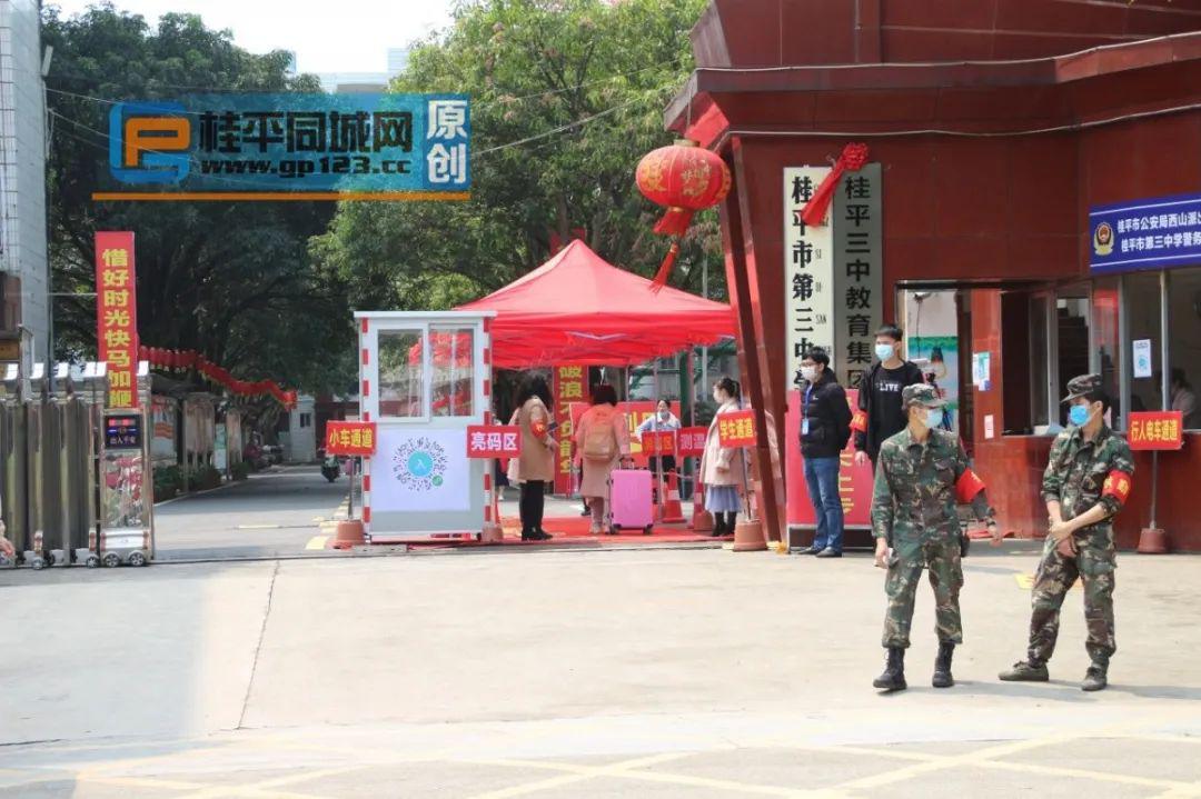 桂平市第三中学桂平市第一中学,门口处的学生提着大包小包,在家长